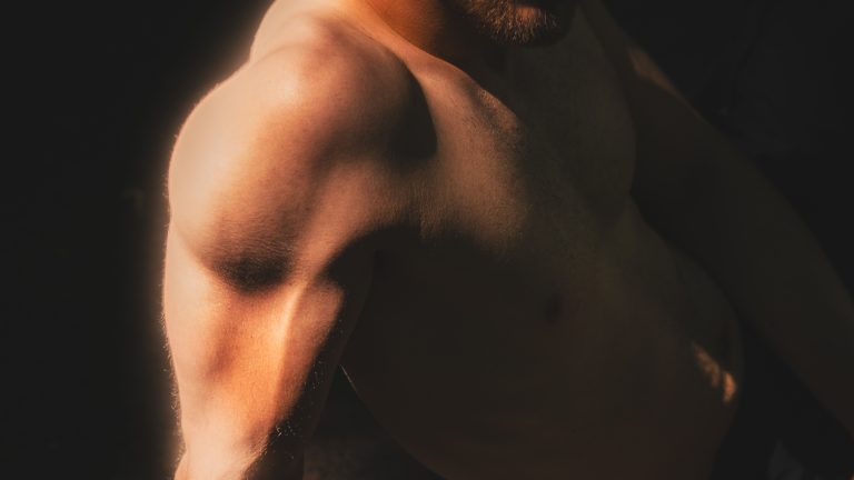 Le détail d'une épaule nue sous une lumière chaude