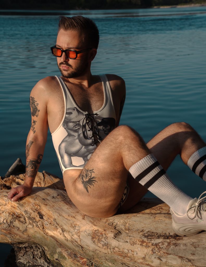 Un homme en body pose au soleil le long de l'eau
